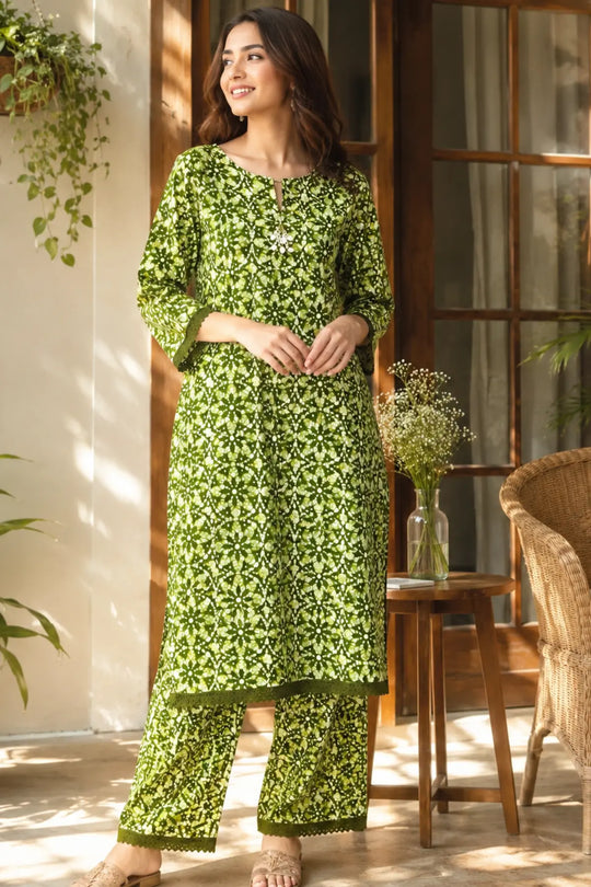 A woman models a olive green batik printed kurta and trouser set.