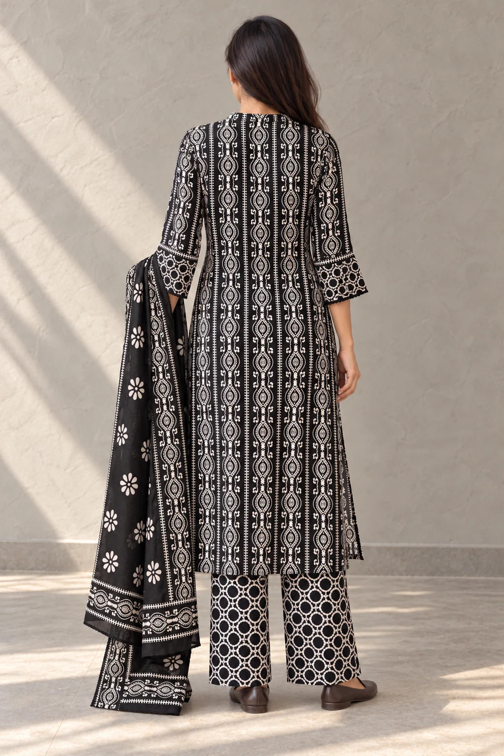 Back view of the black batik kurta set with the dupatta over one arm