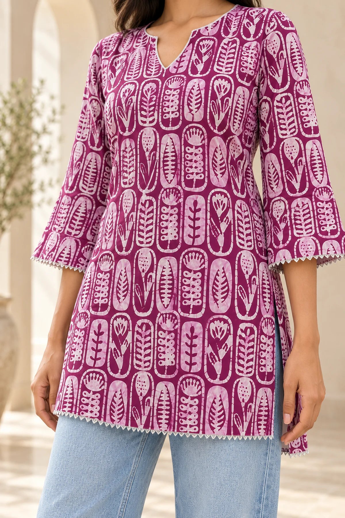 Detail of hand-printed wine batik motifs and gota lace trim at hem and side slit