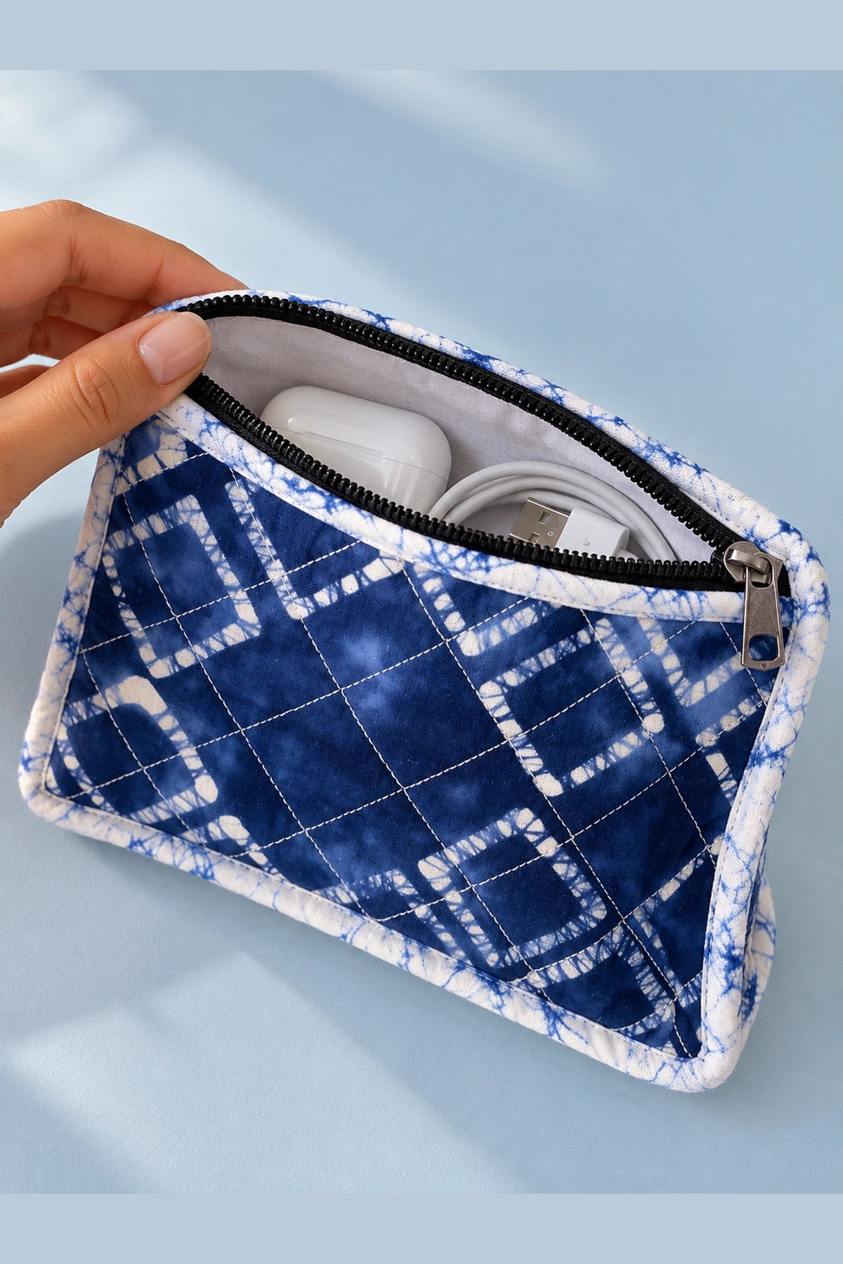 Quilted Batik Utility Pouch in Blue Shibori Check print – open, with earbuds and cables inside | Shades of You