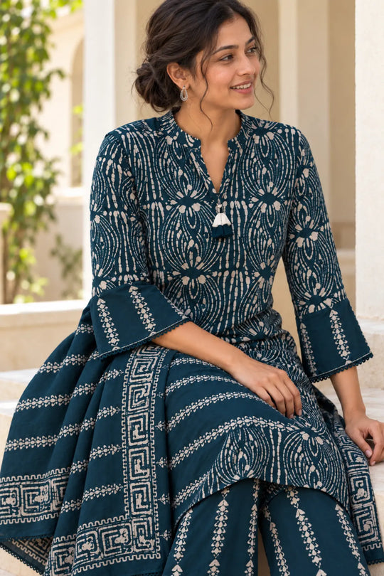 Woman seated in a rama green Deewani batik kurta set with bordered dupatta