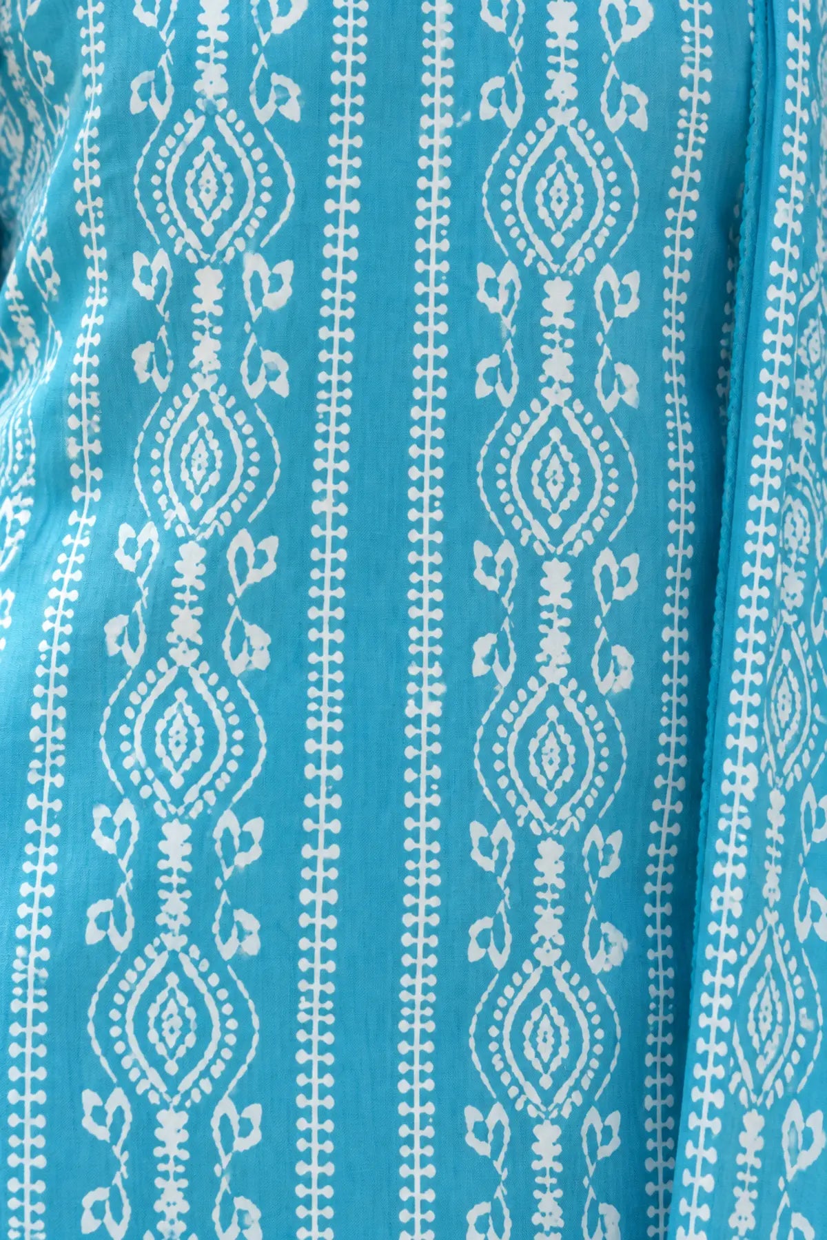 Close-up of the white paisley and leaf batik print on sky blue modal