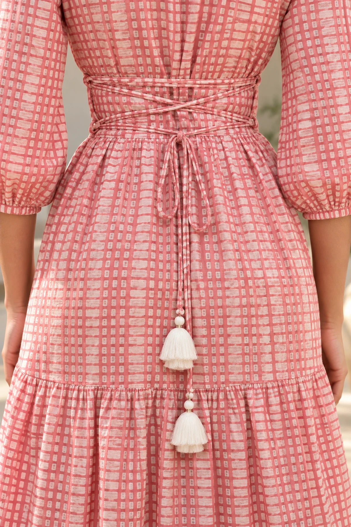 Close-up of adjustable corset back lacing with ivory tassels on Miss Rose batik dress